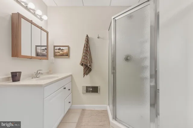 a bathroom with a granite countertop sink mirror and a shower