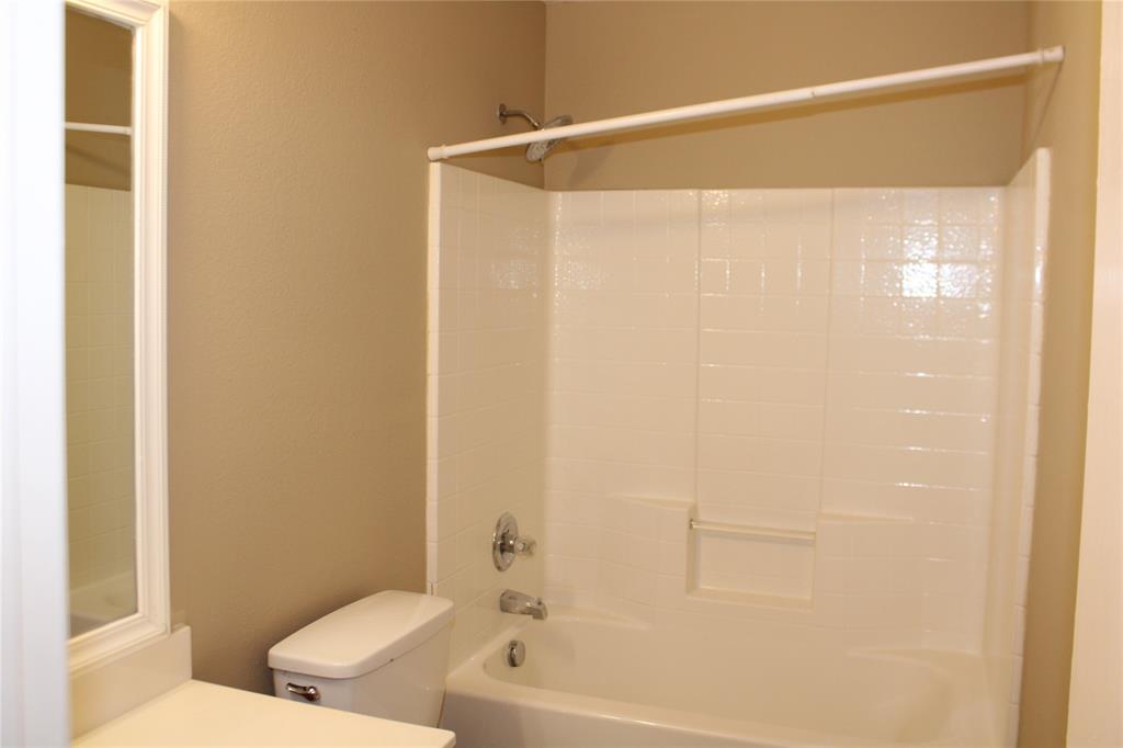 2136 Coelum Court Dallas, TX 75253 - Photo 14 of 29 a bathroom with a shower curtain and a toilet