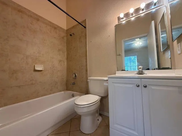 a bathroom with a toilet sink vanity tub and shower