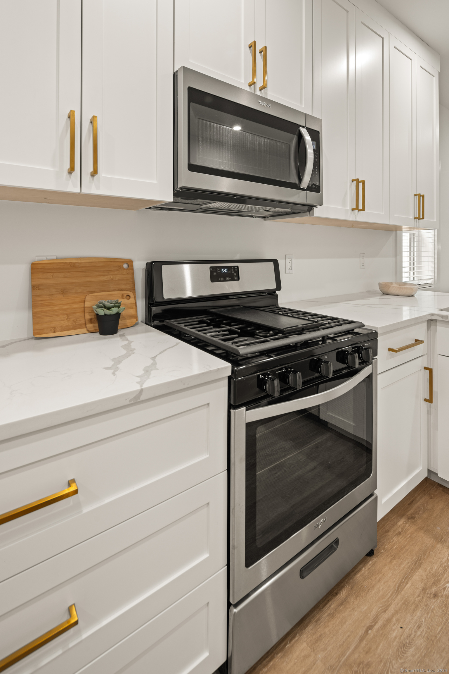 211 Ferry Boulevard, Unit 203 Stratford, CT 06615 - Photo 5 of 16 a kitchen with granite countertop a stove and a microwave