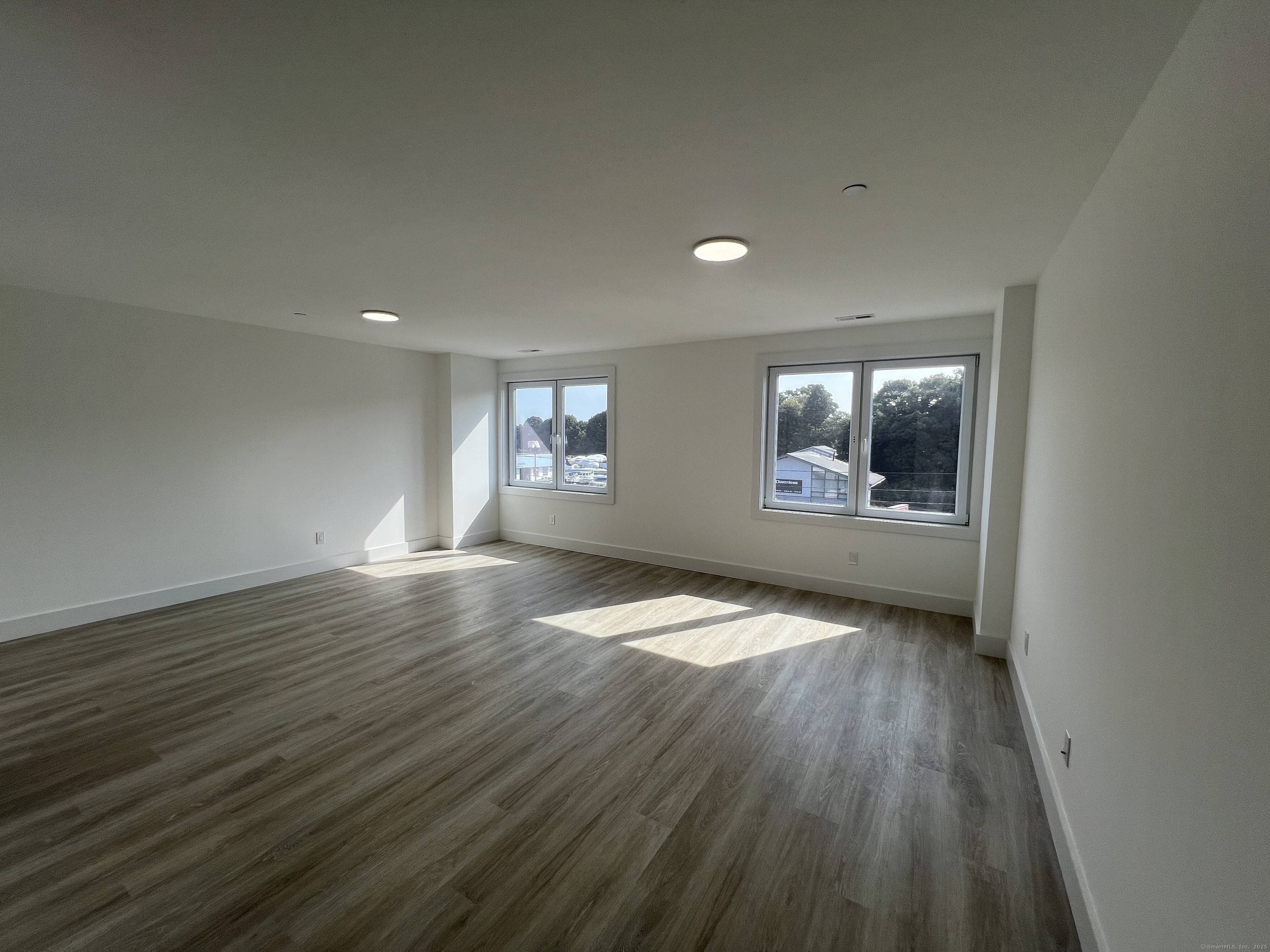 211 Ferry Boulevard, Unit 203 Stratford, CT 06615 - Photo 8 of 16 wooden floor in an empty room with a window