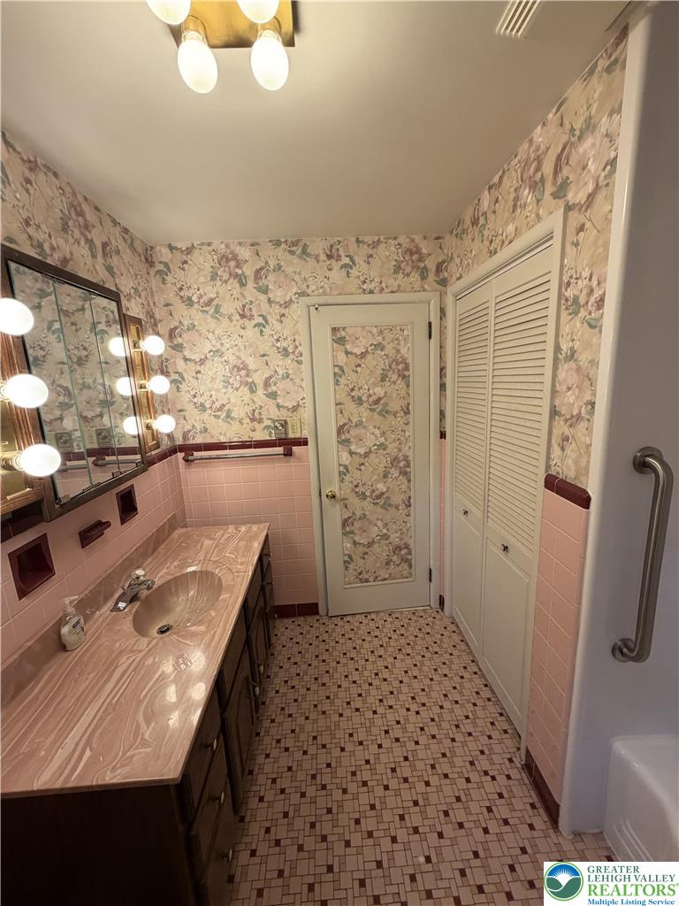 5391 Chapmans Road, Unit 2 Orefield, PA 18069 - Photo 8 of 22 A well-lit primary bathroom featuring a vanity with a large mirror and tile flooring.