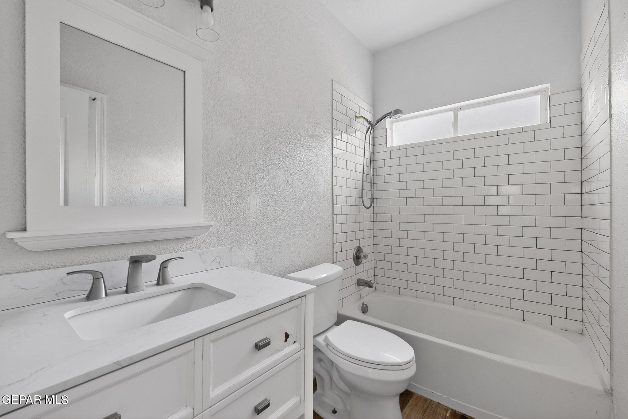 3626 Dominican Street El Paso, TX 79936 - Photo 12 of 20 a bathroom with a granite countertop sink a toilet and shower