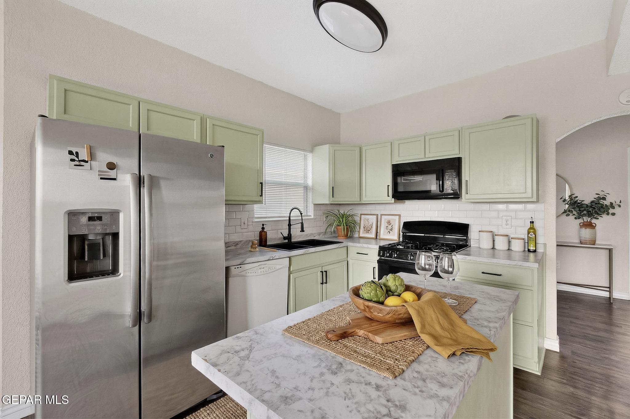 3626 Dominican Street El Paso, TX 79936 - Photo 5 of 20 a kitchen with stainless steel appliances granite countertop a refrigerator a stove top oven a sink dishwasher and white cabinets with wooden floor