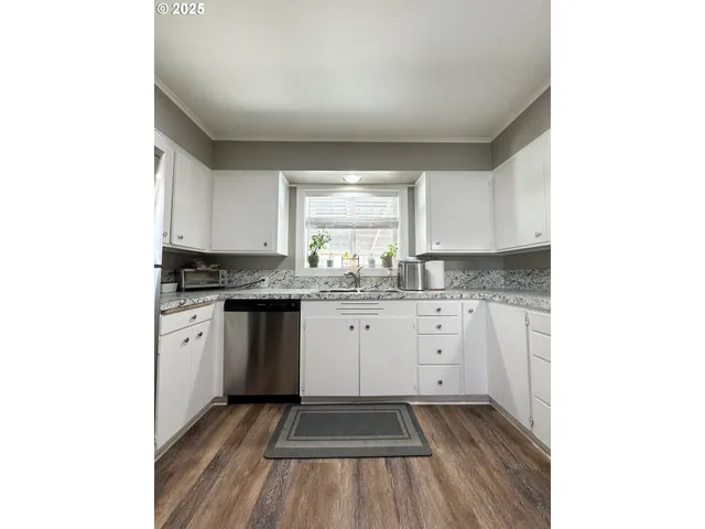 a kitchen with granite countertop white cabinets and white appliances