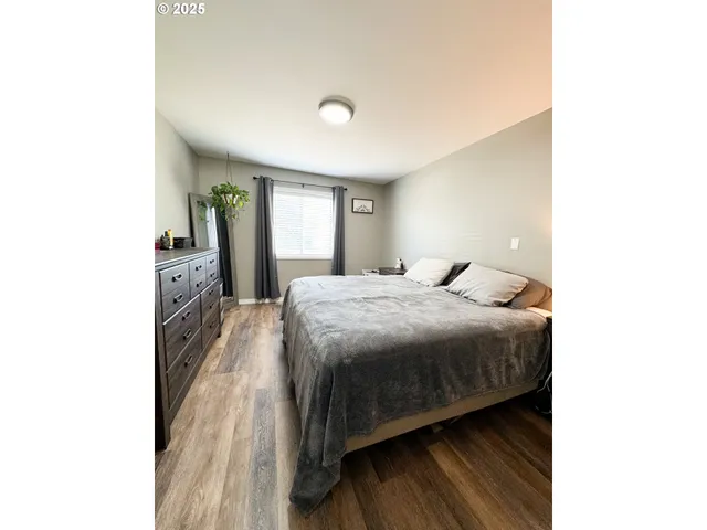 a spacious bedroom with a bed and a dresser