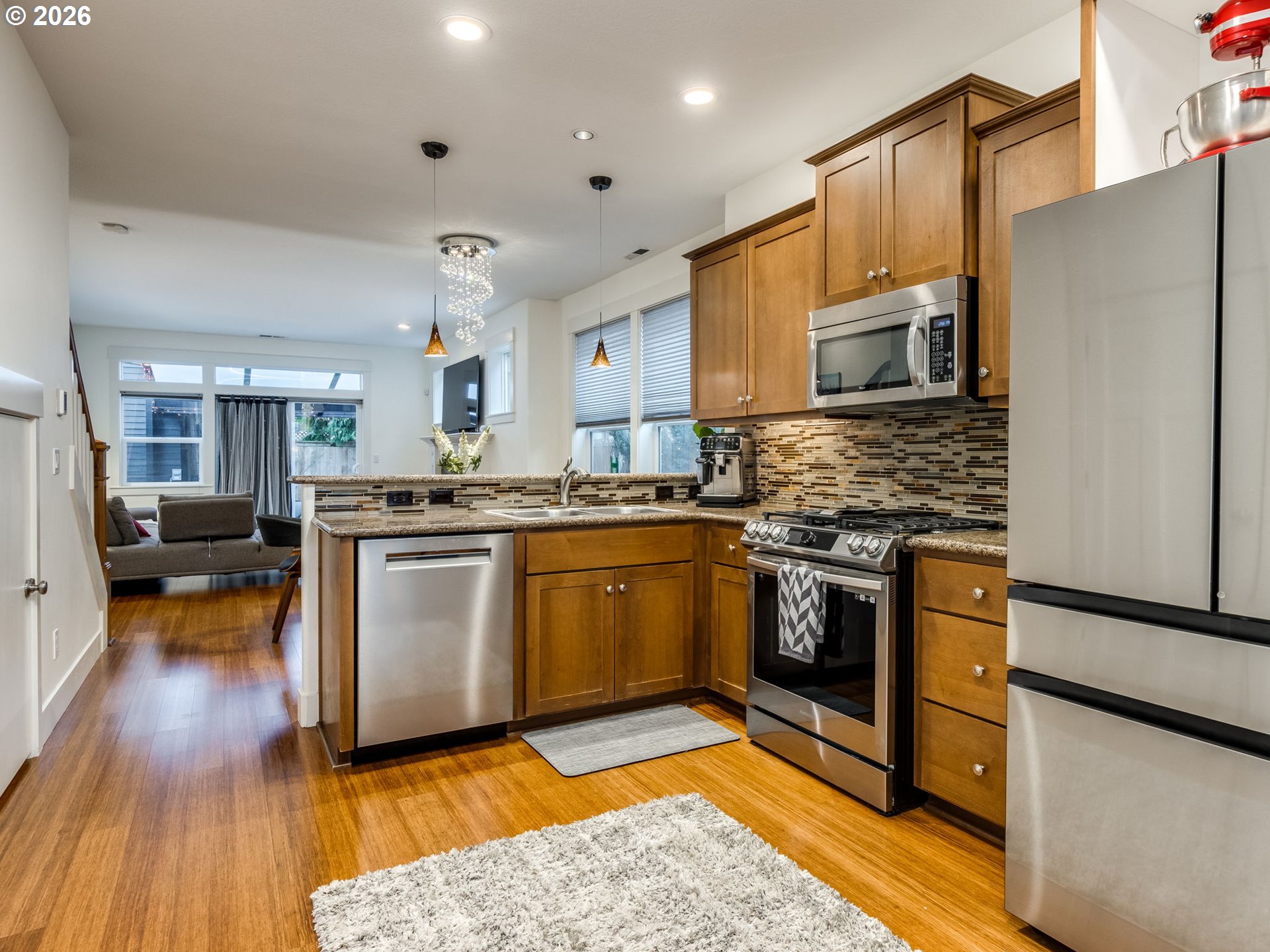 5619 Southeast Carlton Street Portland, OR 97206 - Photo 5 of 30 a kitchen with stainless steel appliances granite countertop a refrigerator a stove top oven a sink dishwasher and a refrigerator with wooden floor