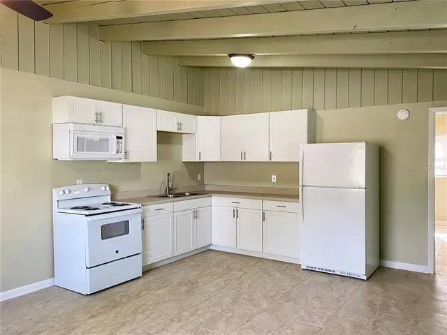 a kitchen with cabinets appliances and a window