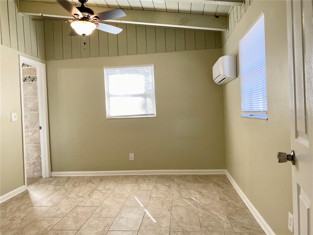 913 East 123rd Avenue, Unit A Tampa, FL 33612 - Photo 7 of 8 a view of a room with window and a chandelier fan