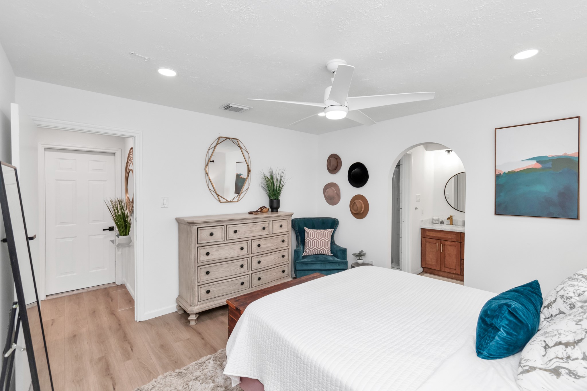 2718 Lazy Spring Drive Houston, TX 77080 - Photo 14 of 32 Large primary bedroom with an open, airy feel and great natural light. White oak-look LVP floors run throughout, with easy access to the vanity area through an arched entry. Plenty of space for a full furniture setup.