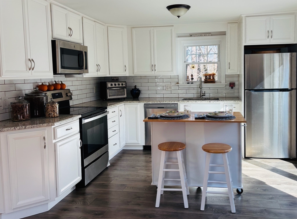 21 Highland Park Road Rutland, MA 01543 - Photo 10 of 41 a kitchen with stainless steel appliances granite countertop a stove a sink a refrigerator and white cabinets