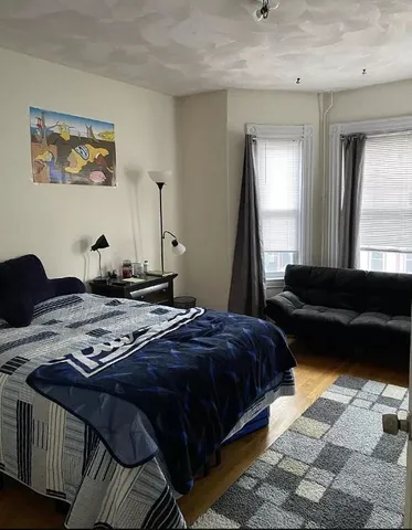 a bedroom with a bed a couch and a window