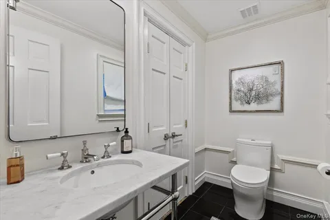 a bathroom with a toilet a sink and mirror