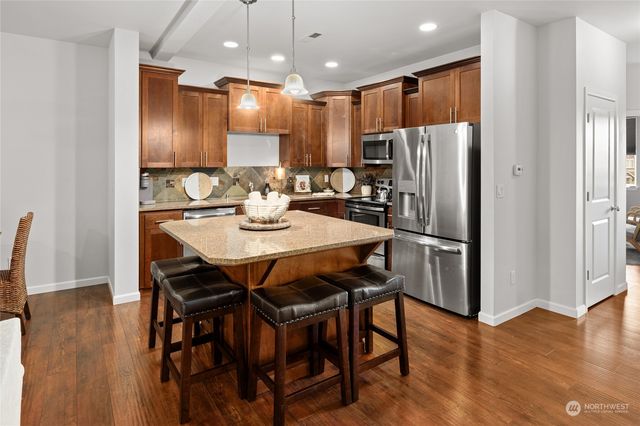 a kitchen with a stove a sink a microwave and wooden cabinets