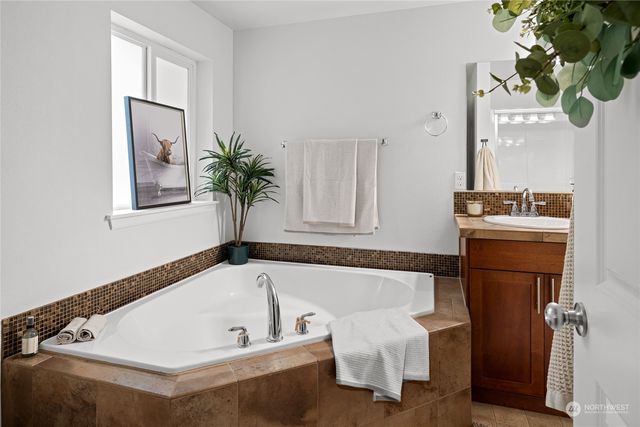 a bathroom with a granite countertop double vanity sink and a mirror