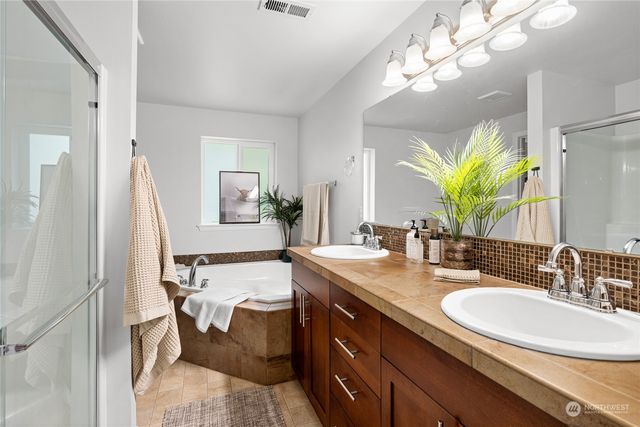 a en suite bathroom with a granite countertop sink and a mirror