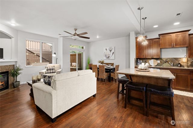 a kitchen with stainless steel appliances kitchen island granite countertop a table chairs and a refrigerator