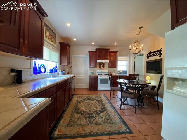 a kitchen with stainless steel appliances granite countertop sink wooden cabinets dining table and chairs