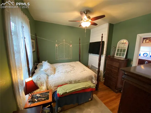 a bedroom with a bed window and a flat screen tv