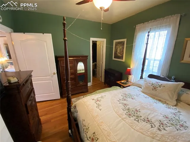 a bedroom with a bed a flat screen tv and a dresser