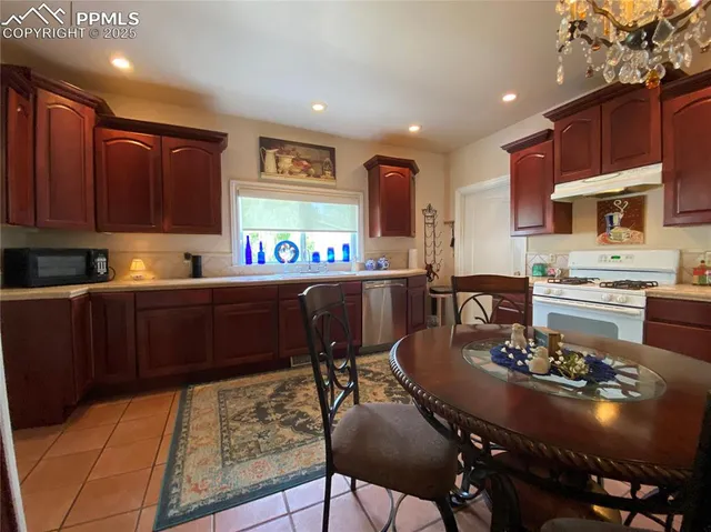 a kitchen with a dining table chairs and stove
