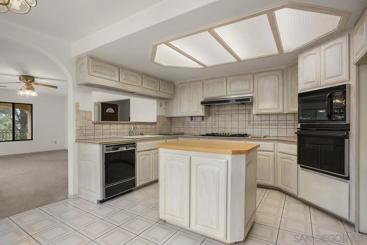 3130 Goldfinch Street San Diego, CA 92103 - Photo 22 of 59 a kitchen with stainless steel appliances granite countertop a stove sink and cabinets