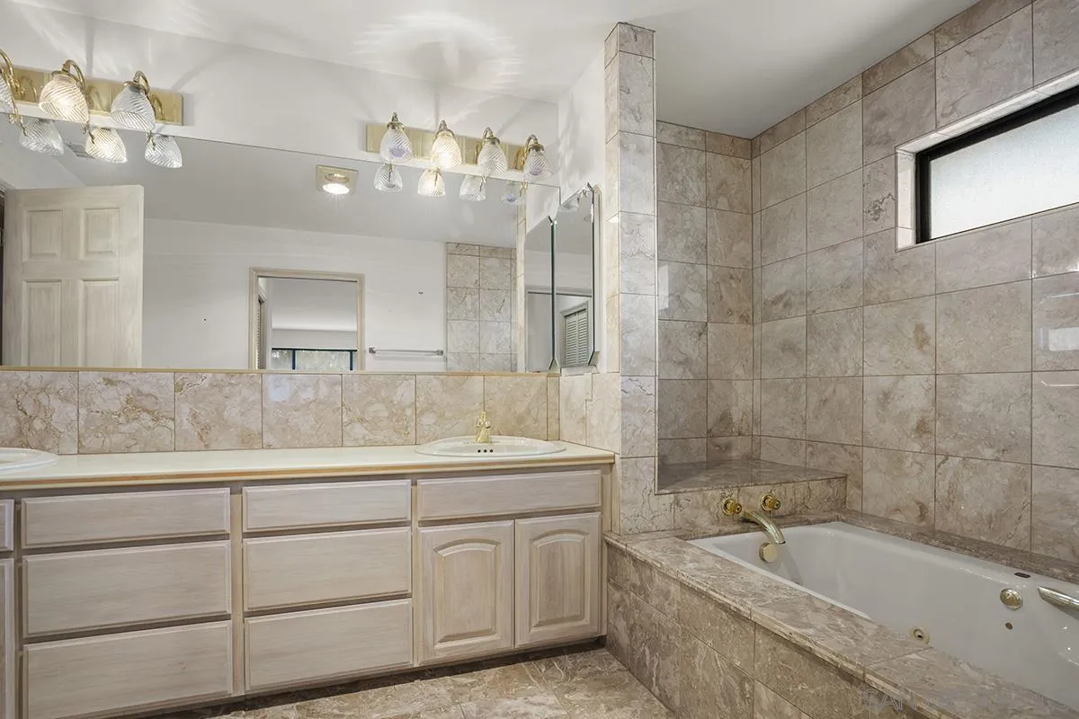 3130 Goldfinch Street San Diego, CA 92103 - Photo 40 of 59 a bathroom with a granite countertop sink a large mirror and bathtub