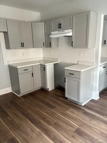a kitchen with granite countertop a sink window and cabinets