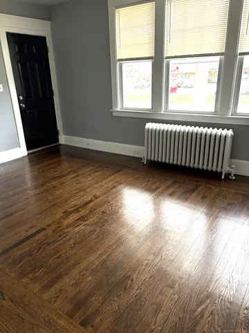 an empty room with wooden floor and fireplace