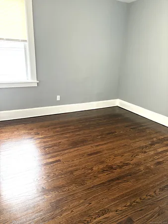 a view of a room with wooden floor and a window