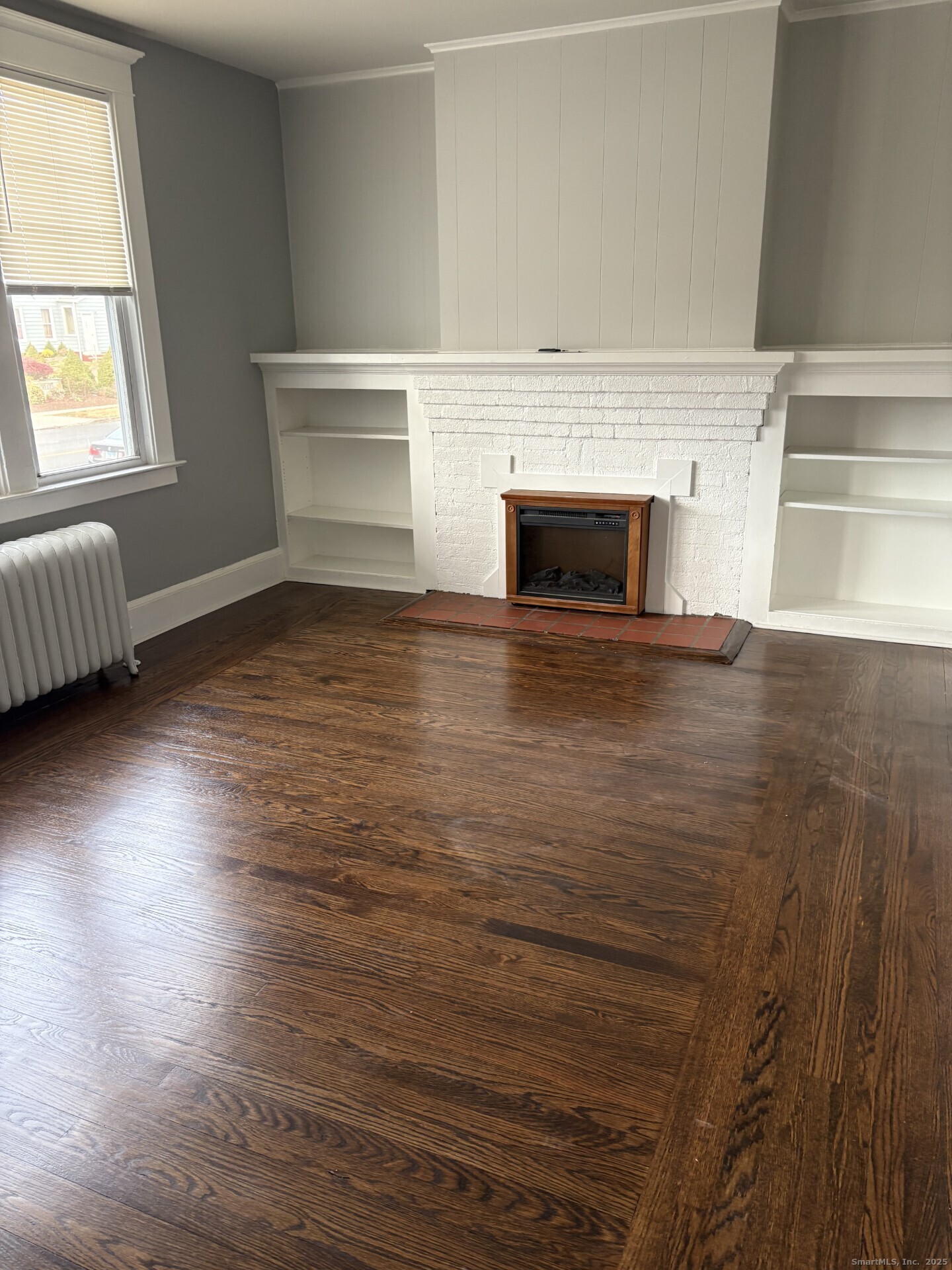 116 Elm Street West Haven, CT 06516 - Photo 6 of 14 an empty room with wooden floor and fireplace