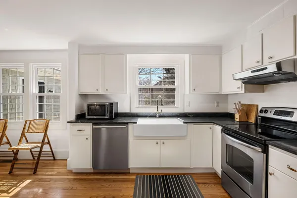 a kitchen with stainless steel appliances a stove a sink a stove and white cabinets
