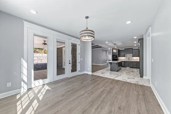 a view of a hallway with front door wooden floor and cabinet