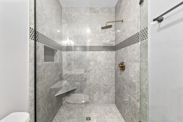 a view of an empty room with a window and a kitchen