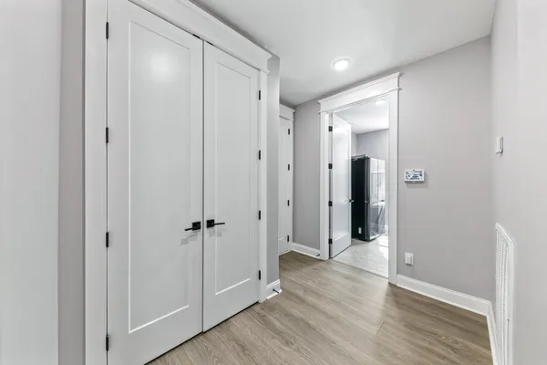 a view of an empty room with a kitchen and a window