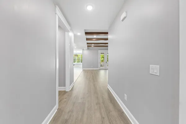 a view of an empty room with wooden floor fireplace and windows