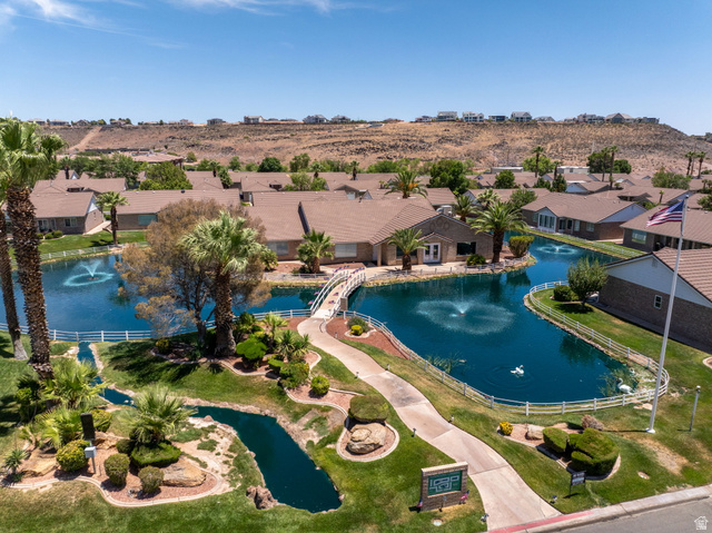 805 South River Road, Unit 70 St. George, UT 84790 - Photo 5 of 38 Community setting featuring a tranquil pond with multiple fountains, surrounded by mature palm trees and manicured landscaping
