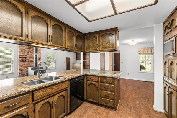 a kitchen with stainless steel appliances granite countertop a stove and cabinets with wooden floor