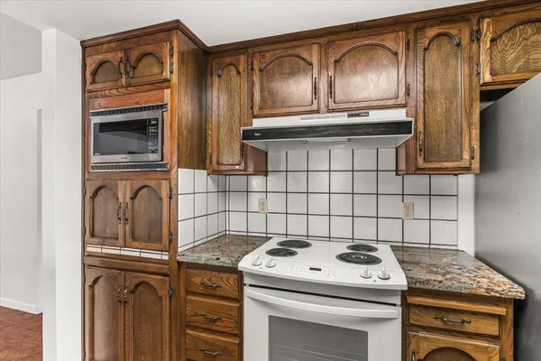 a large kitchen with stainless steel appliances granite countertop a sink and cabinets