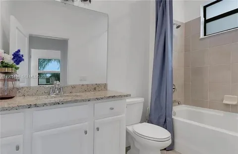 a bathroom with a granite countertop toilet a sink and a bathtub