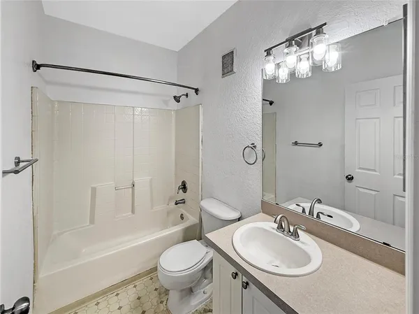 a bathroom with a sink granite tub toilet and shower