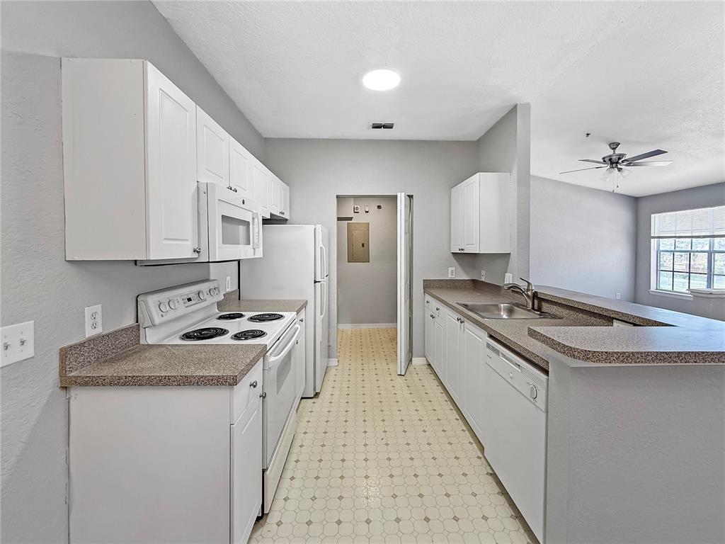 860 Grand Regency Pointe, Unit 200 Altamonte Springs, FL 32714 - Photo 4 of 23 a kitchen with stainless steel appliances granite countertop a stove and a sink