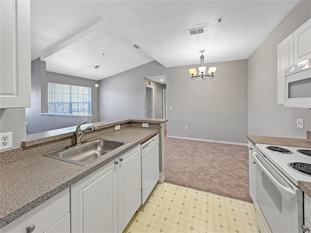 860 Grand Regency Pointe, Unit 200 Altamonte Springs, FL 32714 - Photo 6 of 23 a kitchen with a sink and a stove