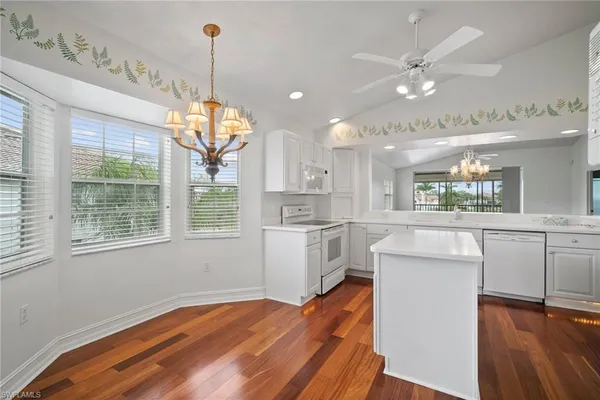 a kitchen with kitchen island white cabinets and wooden floor