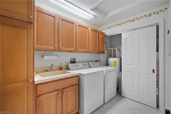 an empty room with chandelier fan and windows