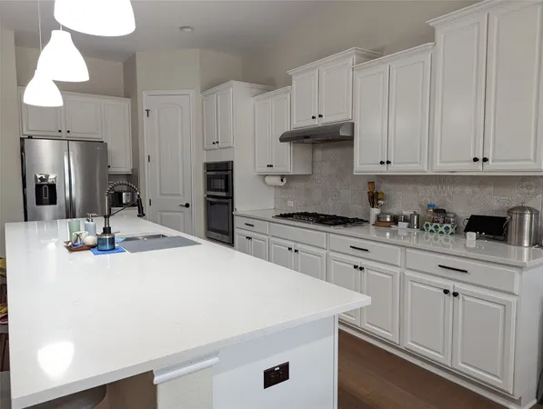 a kitchen with granite countertop white cabinets and white appliances