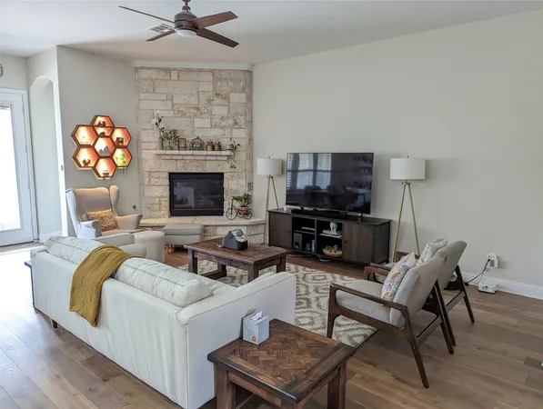 a large kitchen with kitchen island a sink dishwasher a stove a dining table and chairs with wooden floor