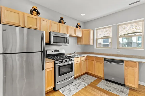 a kitchen with stainless steel appliances granite countertop a refrigerator sink stove microwave and cabinets