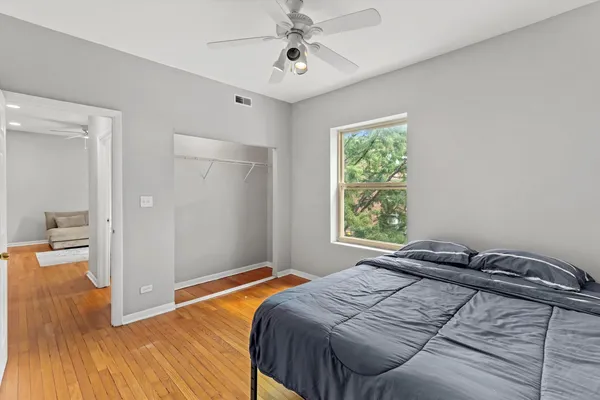 a bedroom with a bed and wooden floor