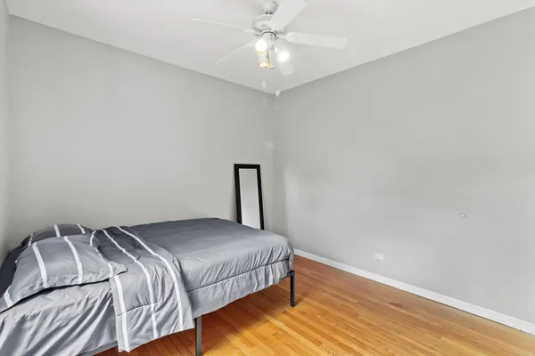 a bedroom with a bed and a ceiling fan